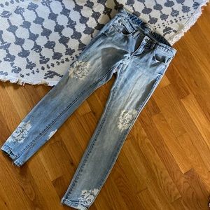 Free People distressed ankle length jeans w/ floral pattern.